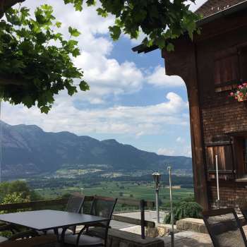 Traditional building with sunny terrace and mountain panorama in the background