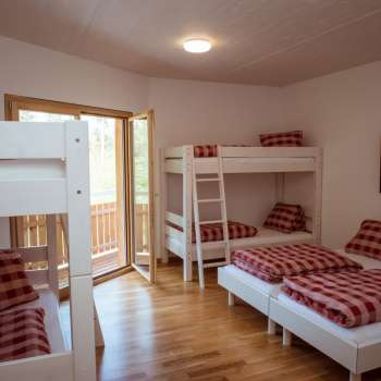 Family-friendly multi-bed room with bunk beds and single beds in the guest house at Camping Mittagsspitze.