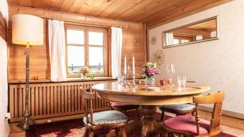 Cozy dining room with wood paneling, round dining table and rustic interior