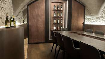 Elegant tasting room of the WY Weinbar with vaulted ceiling and elegant wooden table for exclusive wine tastings.