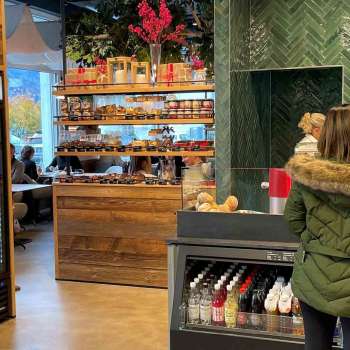Customers at the checkout, surrounded by inviting wooden decorations and fresh products