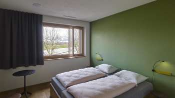 Twin room with a green wall at the Schaan-Vaduz Youth Hostel