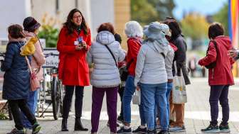 Guided City-ClassicTour in the town of Vaduz Tour group with city guide in red coat on a guided tour through the center of Vaduz in Liechtenstein