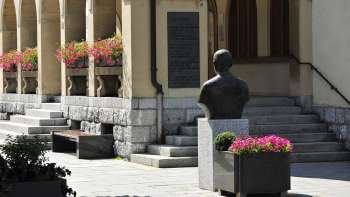 View of the entrance area of Vaduz Town Hall with flower arrangements, historical bust and wide stone steps - a cultural landmark in the center of Vaduz.