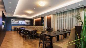 Elegant room in the Kommod restaurant with symmetrical arrangement and cozy atmosphere.