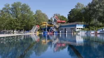 View of the large swimming pool with colorful slide landscape at the Mühleholz swimming pool in Liechtenstein.