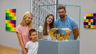 Family looking at a golden sculpture in the Liechtenstein Art Museum - art enjoyment for young and old in the heart of Vaduz.