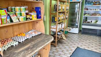  Interior view of the Aeulehof farm store with shelves full of regional products, including eggs and preserves.