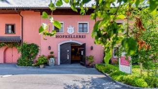 View of the main entrance to the Court Winery with open door, coat of arms and vines - Winery of the Prince in Liechtenstein