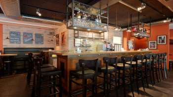 Stylish interior shot of the bar in the New Castle Vaduz with a well-stocked bottle rack and cozy seating area.