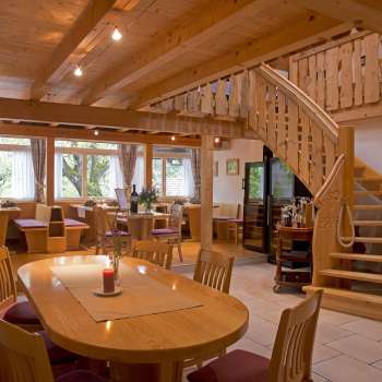 View of the country-style dining room with round staircase and wooden furniture