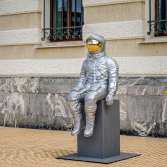 Side view of a silver astronaut sculpture with a gold-colored visor at the Bad Ragartz exhibition in Vaduz
