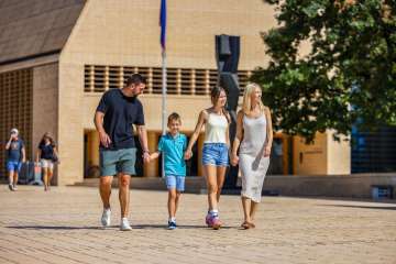 Family strolls in the sunshine through the modern center of Vaduz in Liechtenstein, near the art museum and the government district.