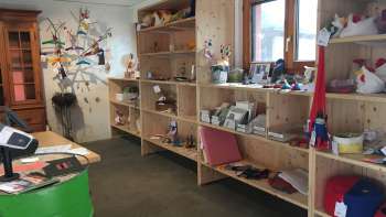 Interior of the Birkahoflädile with wooden shelves full of regional products, decoratively designed with colorful elements - farm store in Liechtenstein.