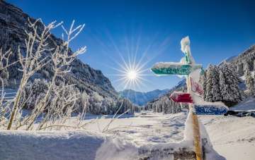Snow-covered signposts and a fantastic winter landscape in bright sunshine in Steg, Liechtenstein.
