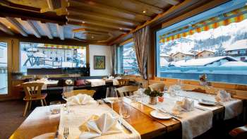 Bright, inviting dining room with large windows and views of snow-capped mountains