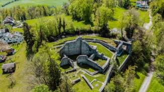 Aerial view of the ruins of Schellenberg Castle in Liechtenstein, surrounded by green countryside - a popular excursion destination with historical flair