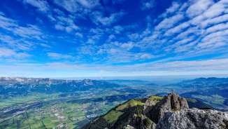 Far-reaching views from the summit of the Drei Schwestern mountain chain over the Rhine Valley and Liechtenstein - impressive Alpine backdrop with cross and distant views