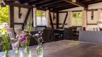 Cozy terrace with wooden furniture and lovely flower decorations in jars