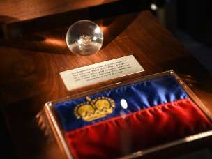 Exhibit in the Liechtenstein TreasureChamber: Liechtenstein flag with golden crown and glass globe with historical find