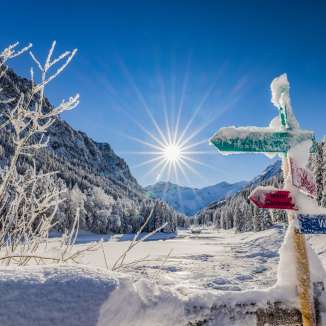 Snow-covered signposts and a fantastic winter landscape in bright sunshine in Steg, Liechtenstein.