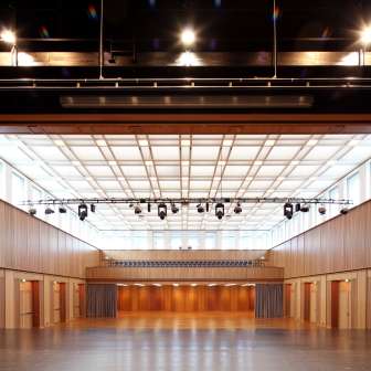 Large event hall with wooden paneling, stage and lighting in Schaan, Liechtenstein - suitable for events, conferences and concerts