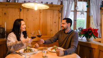 Couple having dinner in the cozy wooden parlor at Gasthof Au Couple having dinner in the cozy wooden parlor at Gasthof Au