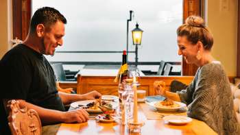 Couple enjoys a cozy candlelit dinner with a view of the outdoor area