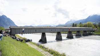 The historic Old Rhine Bridge between Vaduz and Sevelen - covered wooden bridge over the Rhine with a panoramic view of the Alps.