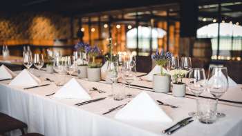 Inviting brewery room with long wooden tables, barrel decorations and stylish lighting