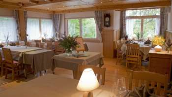 Cozy dining room with set tables and dimmed lighting Cozy dining room with set tables and dimmed lighting