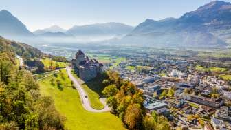 Aerial view of Vaduz Castle with a view over the city of Vaduz and the Rhine Valley on a clear fall day