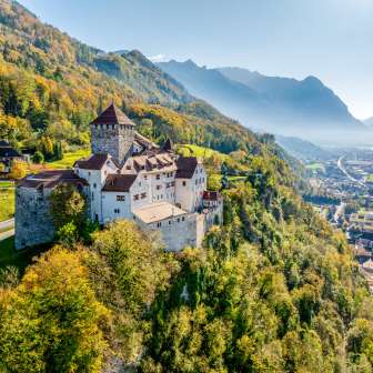 Vaduz Castle in Liechtenstein in the golden fall, with a view of the Alpine Rhine Valley and the city of Vaduz