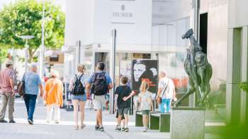 People stroll through the modern pedestrian zone of Vaduz past the Liechtenstein Art Museum