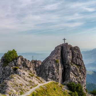 Two summit crosses on the rocks of the Drei Schwestern mountain chain with views over the Rhine Valley along Route 66 in Liechtenstein