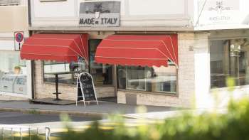 Exterior view of the Made in Italy restaurant with striking red awning in Vaduz.