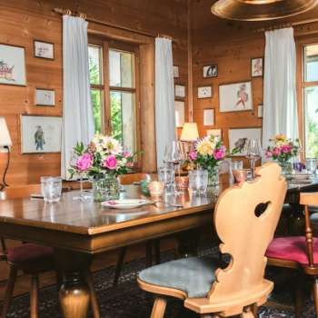 Inviting dining room with wooden ceiling, lovingly decorated table and bright window view