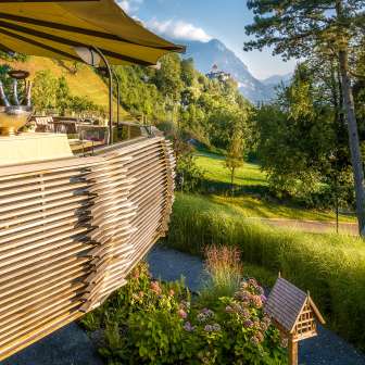Evening sun on the terrace of the Park Hotel Sonnenhof in Liechtenstein, with a view of Vaduz Castle and the picturesque Alpine landscape
