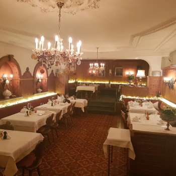 Long dining room with elegantly laid tables and atmospheric lighting