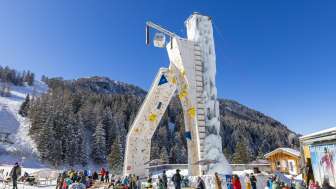 Winter fun at the Malbun ice tower The icy climbing tower in Malbun surrounded by winter guests against an alpine backdrop - a highlight for winter sports enthusiasts in Liechtenstein.