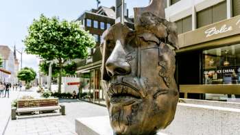 A modern bronze sculpture of a face in the old town of Vaduz