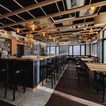 Bright interior of the St. Martins Pub with bar, wooden furniture and large windows.