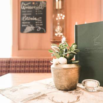Close-up of a table setting with menu cards, flowers and rustic decorations