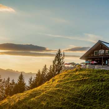 Gadafura hut on a sunny mountain meadow with a view of the mountains and sunset