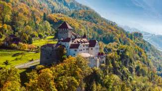 Vaduz Castle on a wooded hill in an autumnal landscape in Liechtenstein