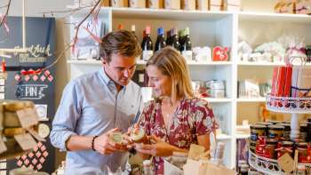 A couple discovers regional specialties in the Hoi-Laden in Vaduz - experience authentic products from Liechtenstein up close.
