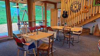 Cozy guest room with wooden elements - The guest room is designed with light-colored wooden furniture and decorative guitars on the wall, warm atmosphere through natural light.