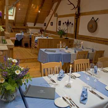 Tables set in blue and white with flowers and crockery in a traditionally decorated room