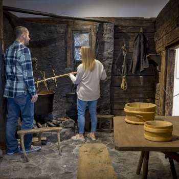 Visitors explore an old smoke kitchen in the Walser Museum Triesenberg