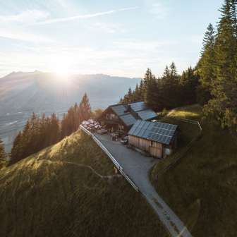 Panoramic shot of a remote mountain hut in Liechtenstein with a view of the Rhine Valley and solar technology on the roof